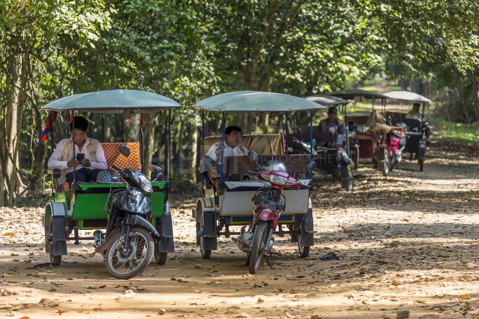 Les chauffeurs de tuk tuk attendent leurs clients près des temples d'Angkor - Tuk tuk drivers are waiting for their clients near Angkor temples